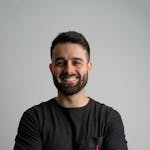Smiling man in a casual black shirt posing for a professional portrait.